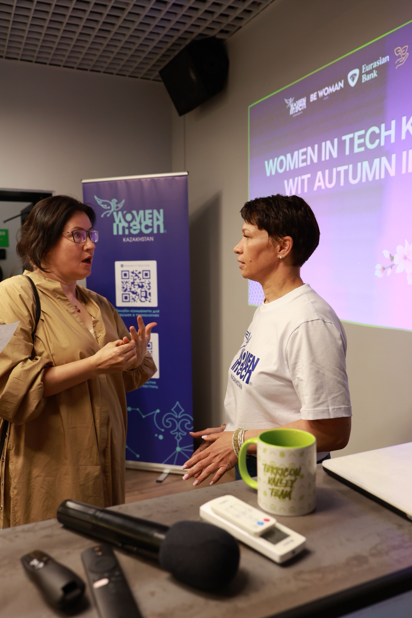 A participant talking with a Women in Tech Kazakhstan representative